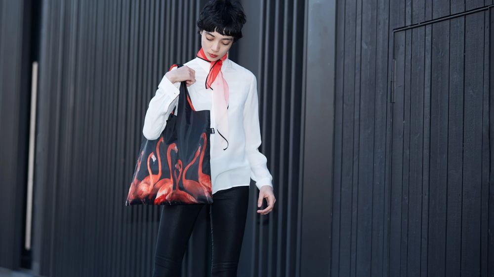 Lány egy Loqi bevásárló táskával amely egy flamingót ábrázol