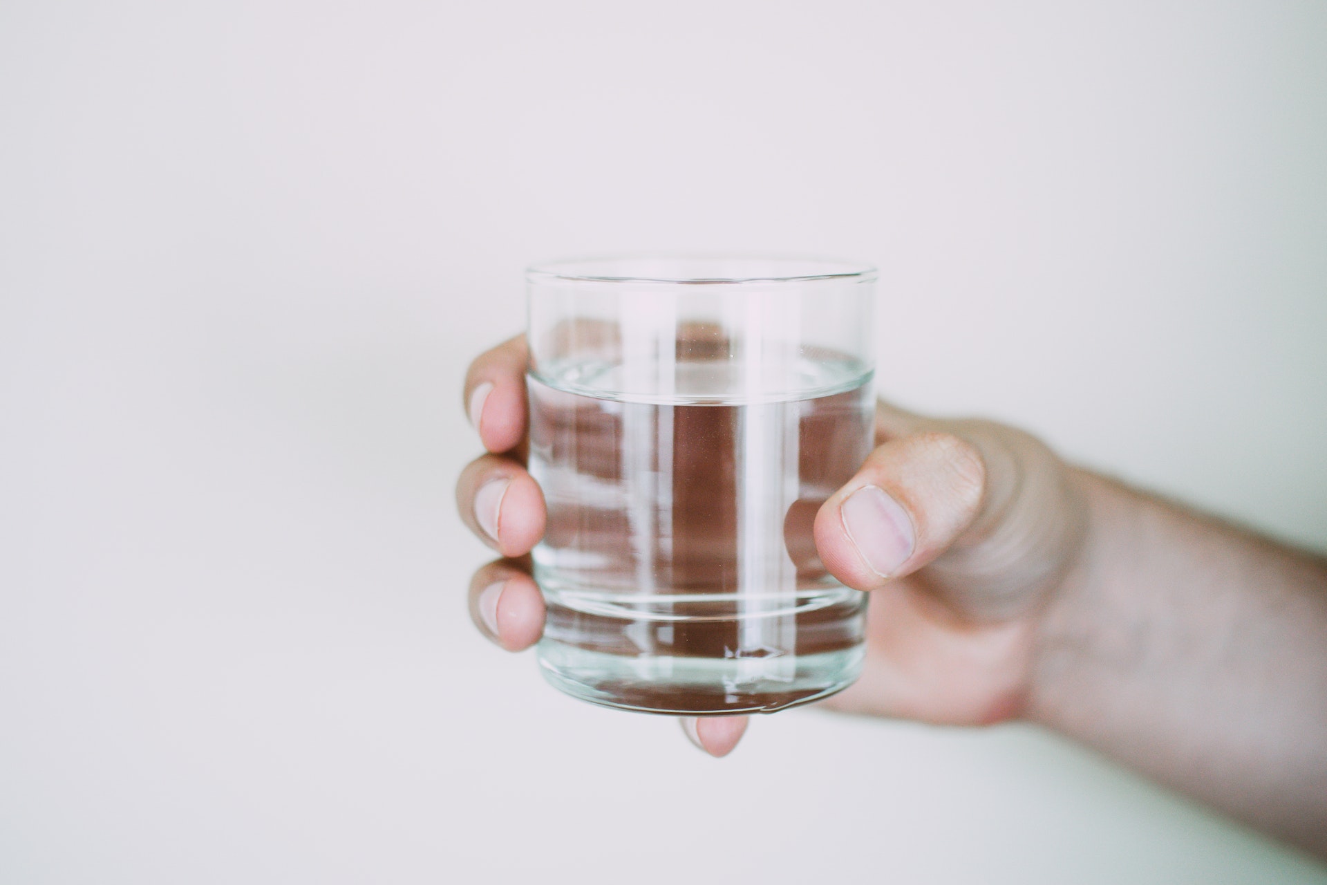 egy pohár tiszta víz egy kézben