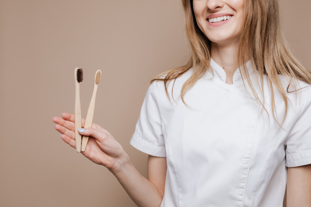 lány eldobható bambusz fogkefékkel a kezében